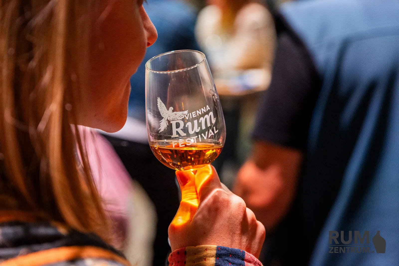 Návštěvnice ochutnává rum z festivalové sklenice